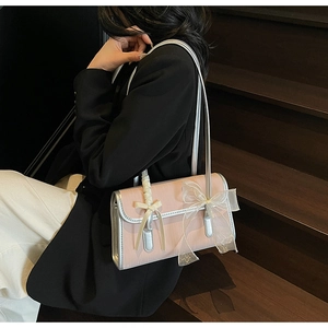 Detailed shot of a pink bow shoulder bag with silver trim and lace ribbon accents