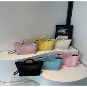 Detailed view of six colorful bucket bags in pink, yellow, and blue on a minimalist display