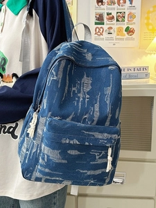 Distressed denim backpack with fringe detail and frayed texture for a casual look