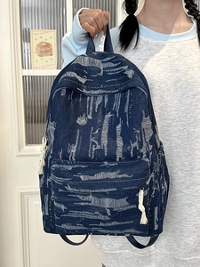 Vintage blue denim backpack with white washed texture and cotton tassel charm