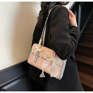 Detail of pink wave texture leather underarm bag with double bow decoration on a model
