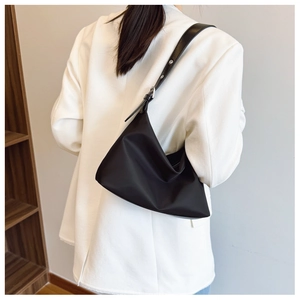 Detail of adjustable leather strap with silver metal buckle on a black shoulder bag