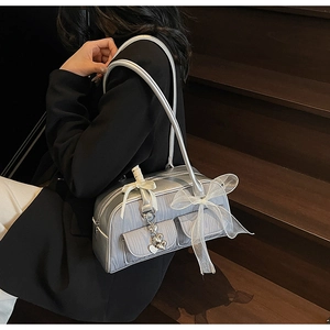 Detailed shot of silver-grey saddle bag with white tulle bow and silver heart pendant