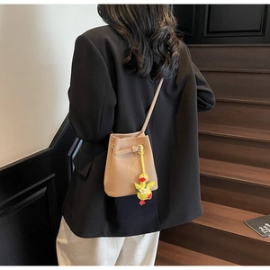Detail of lychee pattern bucket bag in light brown with creative duck charm accessory