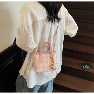 Dettaglio della mini borsa tote rosa trapuntata con ciondolo a forma di orso