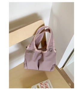 Detail of mauve nylon tote bag hanging on a chair showing texture and stitching
