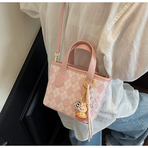 Dettaglio borsa a tracolla a scacchi rosa e crema con stampe a cuore e charms carini