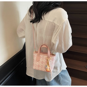 Vista posteriore di una modella con mini borsa tote a scacchi rosa su una scala