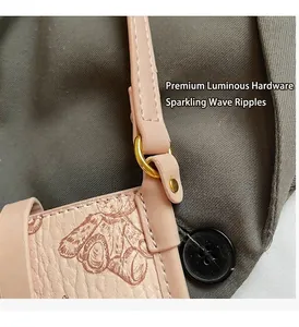 Close-up of pink lychee leather with bear print and gold D-ring hardware detailing