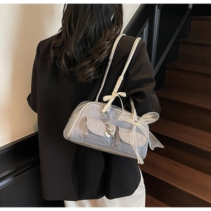 Fashionable grey saddle bag with organza bow and heart charm detail on model