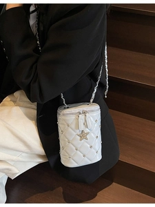 Sac seau blanc matelassé avec breloque étoile et chaîne argentée pour un porté élégant