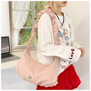 Seitenansicht der rosa gefalteten Halbmond-Tasche mit breitem Schultergurt am Model