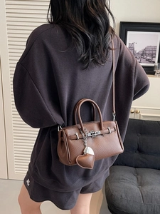 Mini borsa a mano in pelle litchi marrone con chiusura argento in ambiente lifestyle