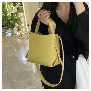Close-up of lemon yellow litchi pattern bucket bag with MACGHEE logo and shoulder strap