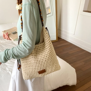 Detail of crochet tote bag featuring intricate hollow weave and decorative wooden beads