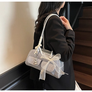 Detail of silver saddle bag with white lace bow and heart-shaped metal pendant