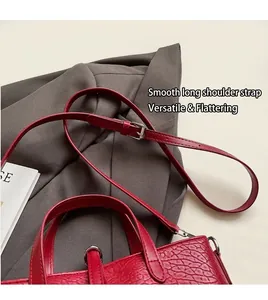 Close-up of red crocodile pattern tote bag with adjustable shoulder strap on blazer