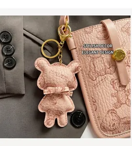 Macro shot of pink litchi grain leather bag with Keddy Bear pendant and gold clasp