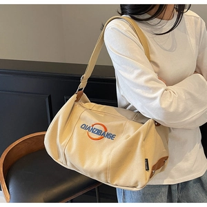 Détails du sac fourre-tout en toile avec broderie bleue et attaches en cuir robuste