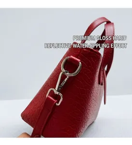 Detail of red croc-embossed leather tote with high-gloss silver hardware and metallic buckle