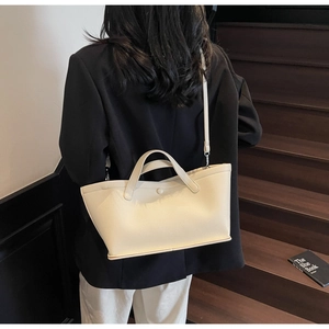 Litchi texture leather bucket bag in cream white shown on model for a stylish look