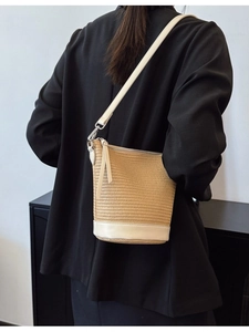 Straw and white leather bucket bag worn as a crossbody bag for casual summer style