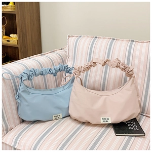 Detailansicht der blauen und rosa plissierten Halbmondtaschen mit weicher Stoffstruktur