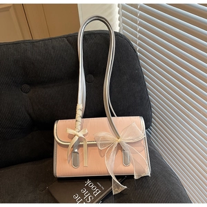 Detail of pink shoulder bag with silver trim and elegant white organza bow decoration