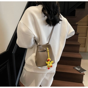 Rear view of a grey lychee pattern leather bucket bag with a yellow duck charm