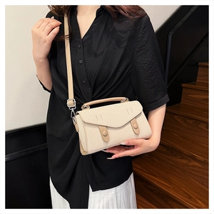 Beige woven texture crossbody bag shown on a model with detailed flap and ring accents