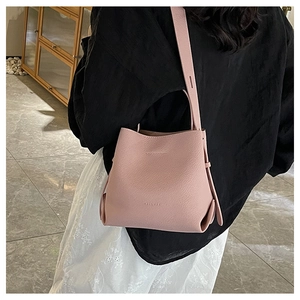 Detail of the litchi texture on the light pink leather bucket bag with brand embossing