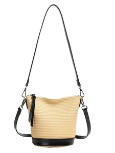 Minimalist straw bucket bag with black leather shoulder strap and metallic hooks