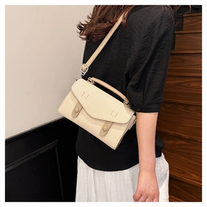 Close-up of cream woven crossbody bag with adjustable strap and leather handle