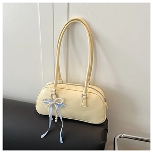 Dettaglio borsa bowling color crema con nastro a quadretti blu e ciondolo di perle