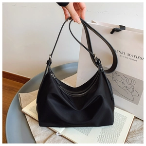 Detail of black crescent hobo bag with smooth zipper and adjustable shoulder strap