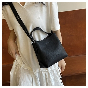 Close-up of black litchi grain leather bucket bag with adjustable shoulder strap