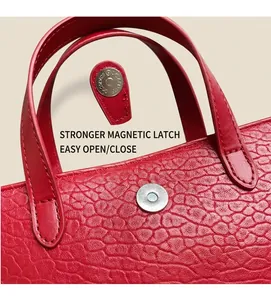 Detailed macro view of red leather handbag with silver magnetic snap closure mechanism