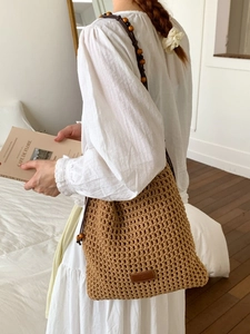 Khaki crochet hollow woven beach bag with wooden beads and leather logo detail for women