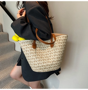 Dettaglio borsa tote in paglia intrecciata con spalline in pelle marrone in stile casual chic