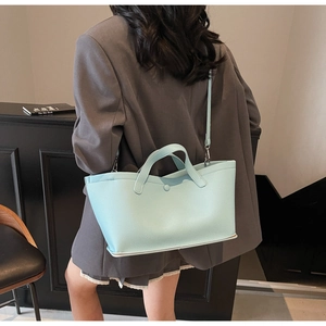 Close-up of light blue lychee pattern bucket bag with metal snap and thin strap