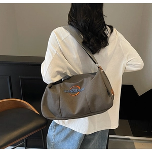 Vue détaillée du dos d'un grand sac fourre-tout en toile marron avec bandoulière