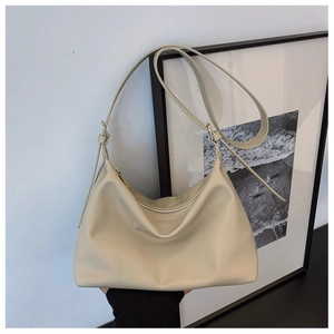 Detail view of cream leather tote bag with soft texture and adjustable shoulder strap