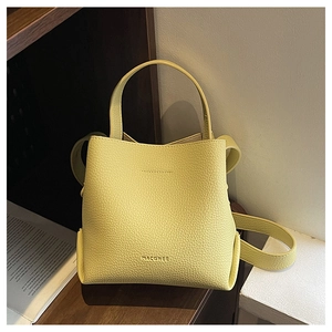 Detail of yellow lychee leather bucket bag with top handle and MACGREE logo