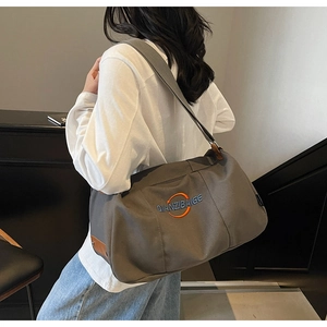 Vue détaillée du sac en toile grise avec finitions en cuir brun et logo
