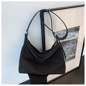Detail of black nylon crescent shoulder bag with silver buckles and adjustable strap