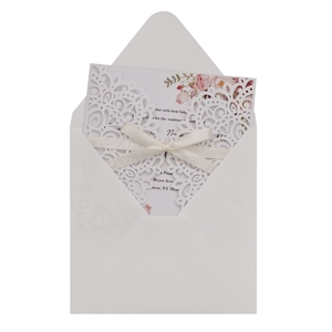 Détail de l'invitation de mariage découpée au laser avec ruban de soie et motif floral