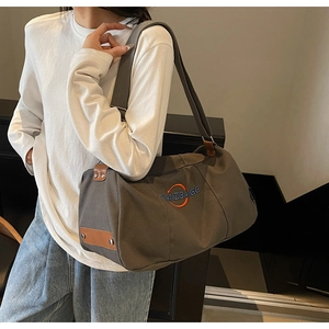 Détail du sac en toile montrant la sangle réglable et le logo de la marque brodé