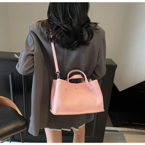 Pink lychee texture bucket bag shown with grey blazer for a modern fashion look