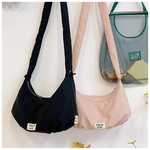 Detailansicht der sichelförmigen Taschen in Schwarz und Rosa mit Falten und Markenlabel