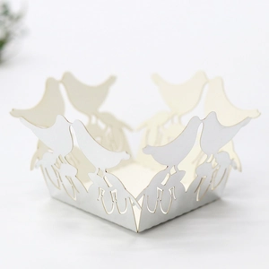 Macro view of laser-cut wedding favor box featuring hollow birds and lace patterns